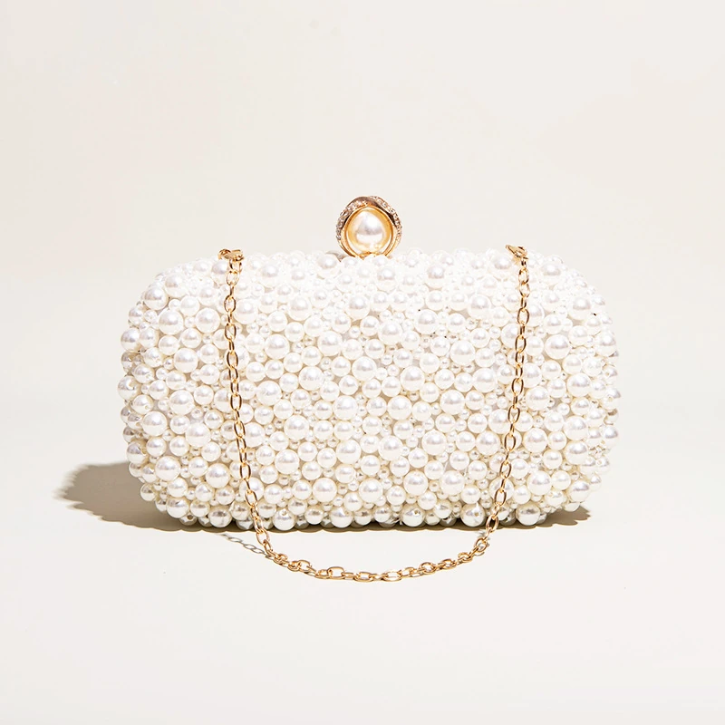 White pearl-look beaded box clutch with gold-tone chain draped over front