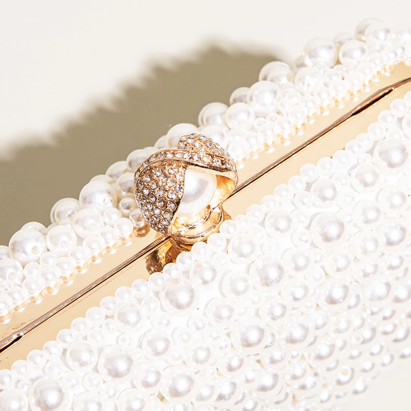 Close-up of jeweled ring clasp and pearl-look beading on box clutch