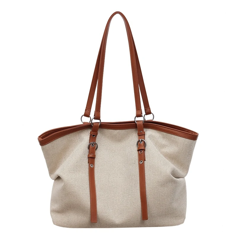 Light fabric tote with tan contrast handles and vertical front tabs