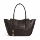 Dark brown winged commuter tote with curved front pocket and charm