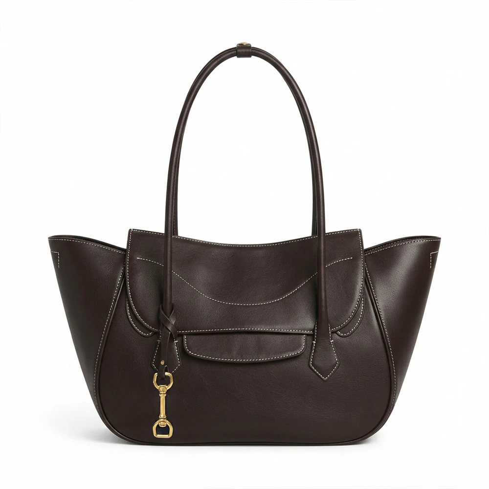 Dark brown winged commuter tote with curved front pocket and charm