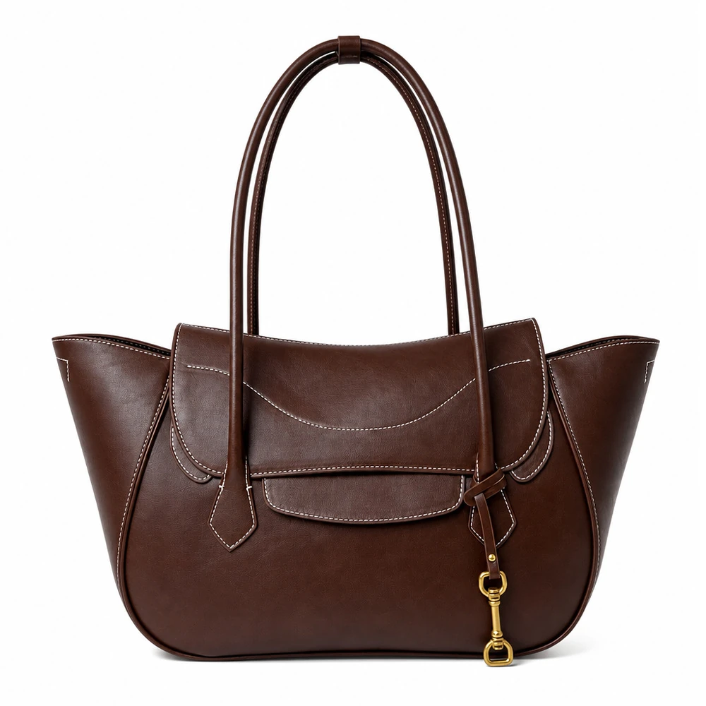 Chestnut brown winged tote with curved front seam and hanging charm
