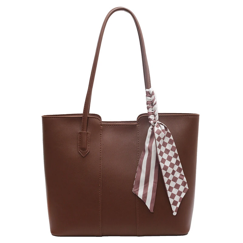 Brown commuter tote with long handles and patterned scarf accent