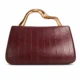 Burgundy evening clutch with vertical seams and sculpted handle