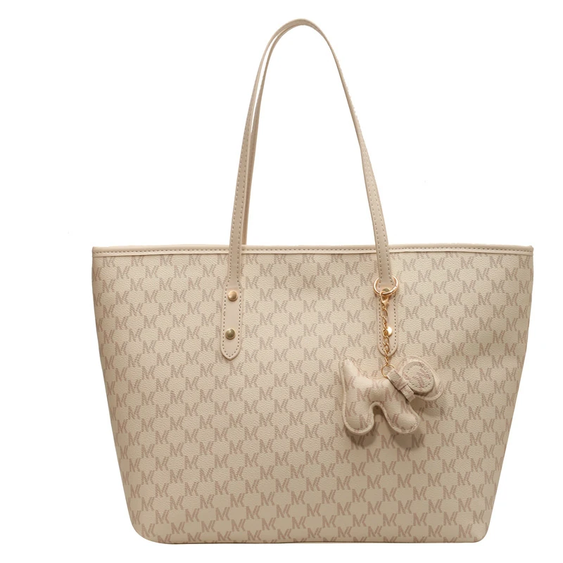 Light beige patterned tote with hanging charm